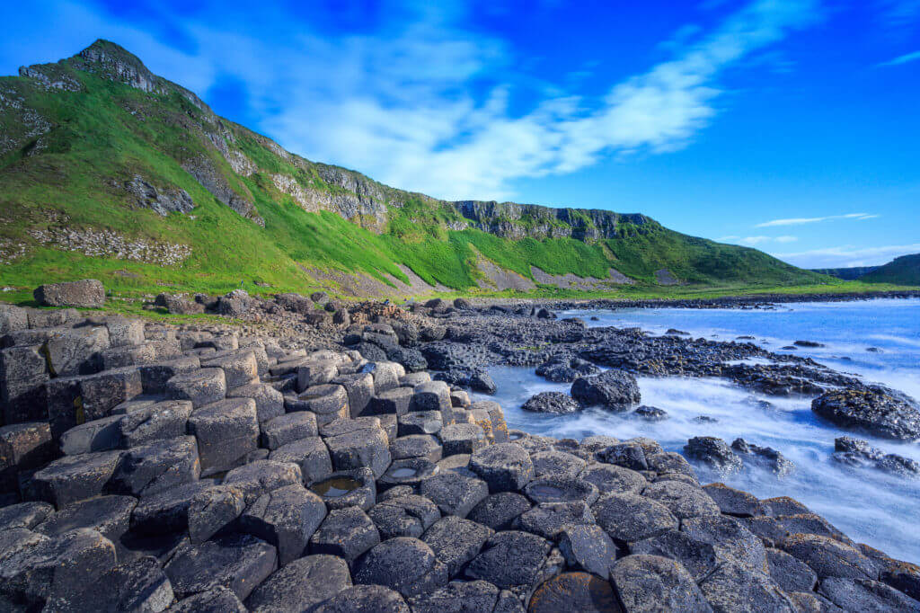 Giant's Causeway: geometric rock formations, green hills